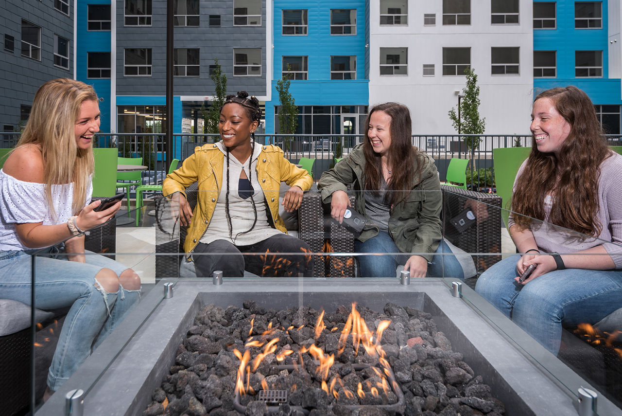 Friends around a fire pit socializing | Blog | Greystar